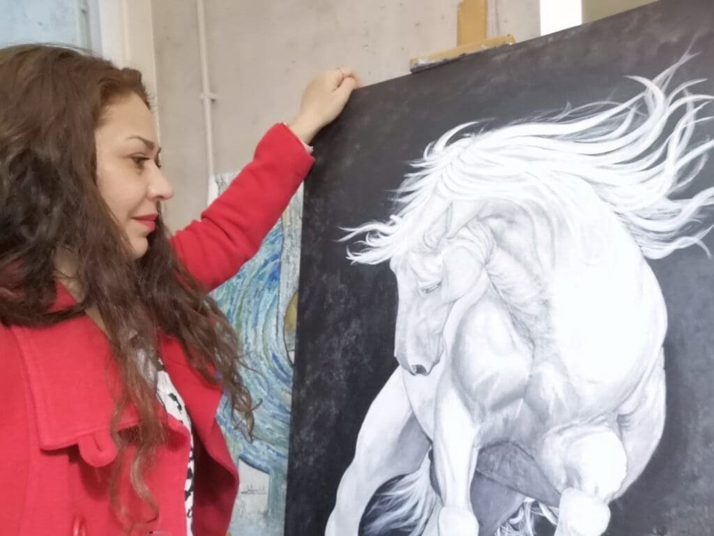 Salomé V.A  junto a una de sus obras de arte en acrílico