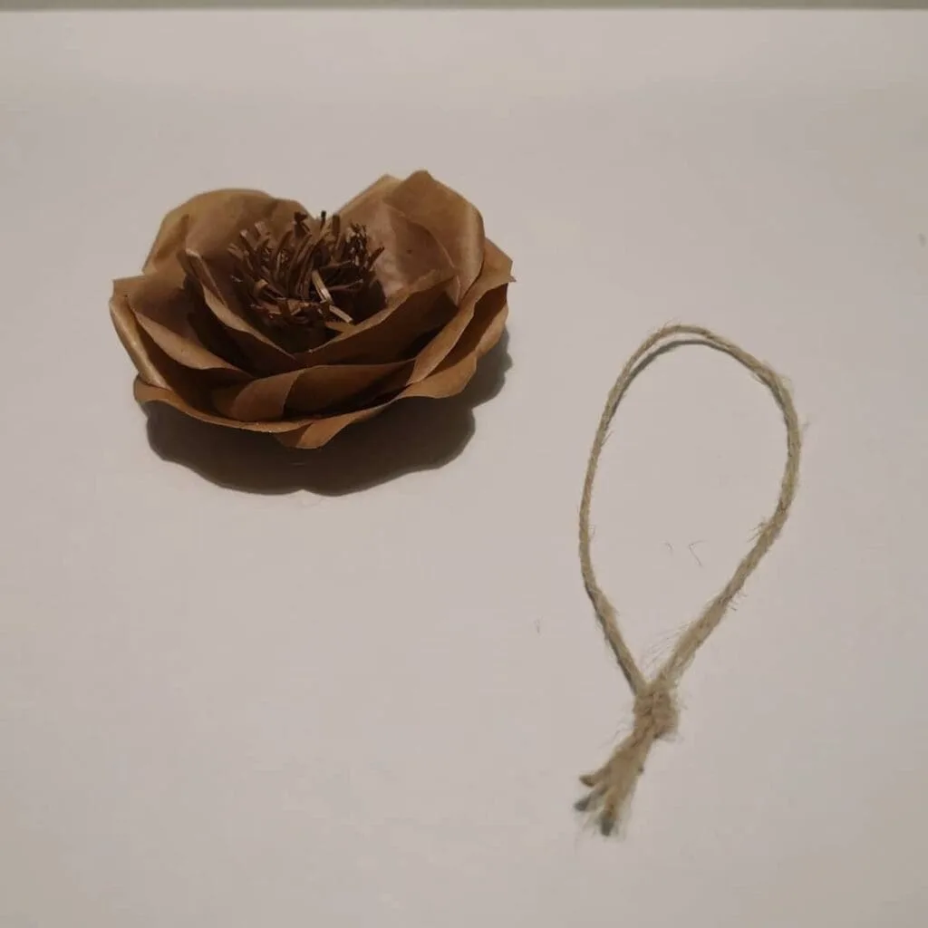 Detalle del proceso de montaje de flores decorativas de papel kraft