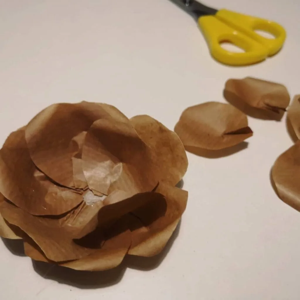 Modelado manual de pétalos de papel kraft durante el proceso creativo