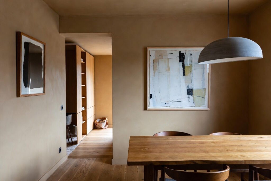 Arte contemporáneo integrado en un comedor de estilo contemporáneo con madera natural y luz natural
