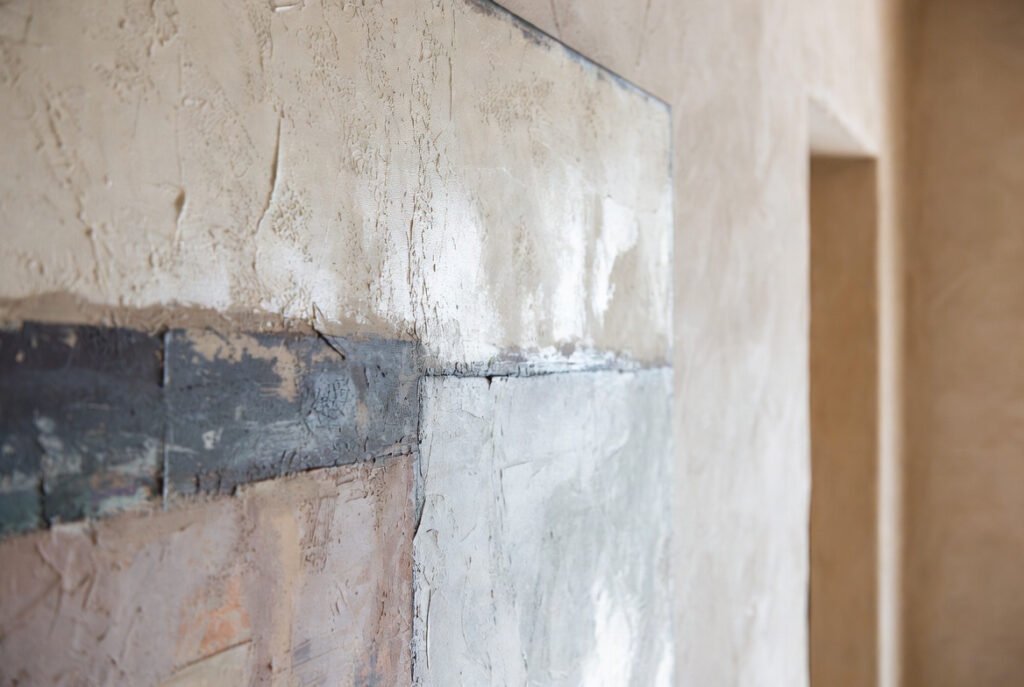 Detalle de una obra de arte contemporáneo mostrando textura, capas y materia, con iluminación natural